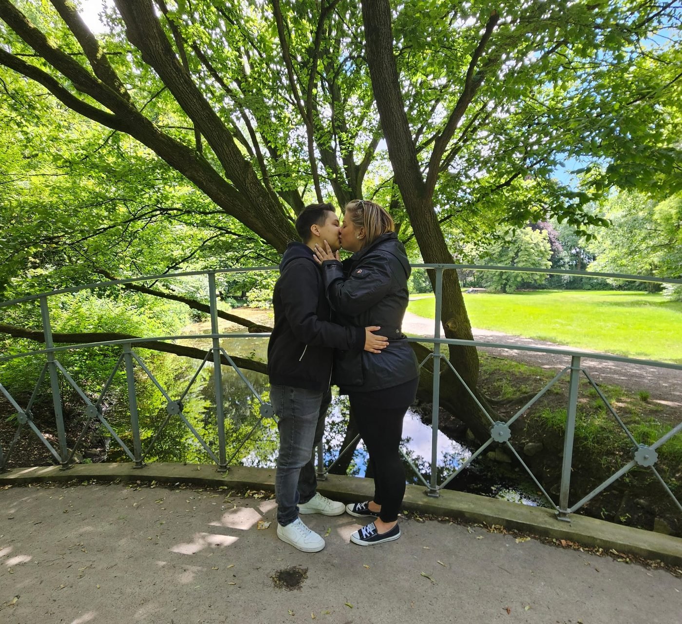Vanessa und Juliane küssen sich in einem Park